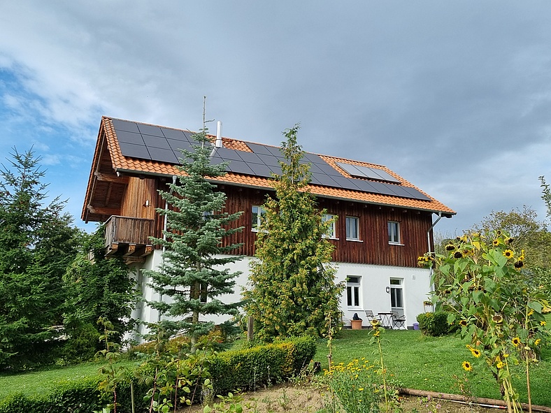 Seitenansicht eines Einfamilienhauses mit Photovoltaik auf dem Dach