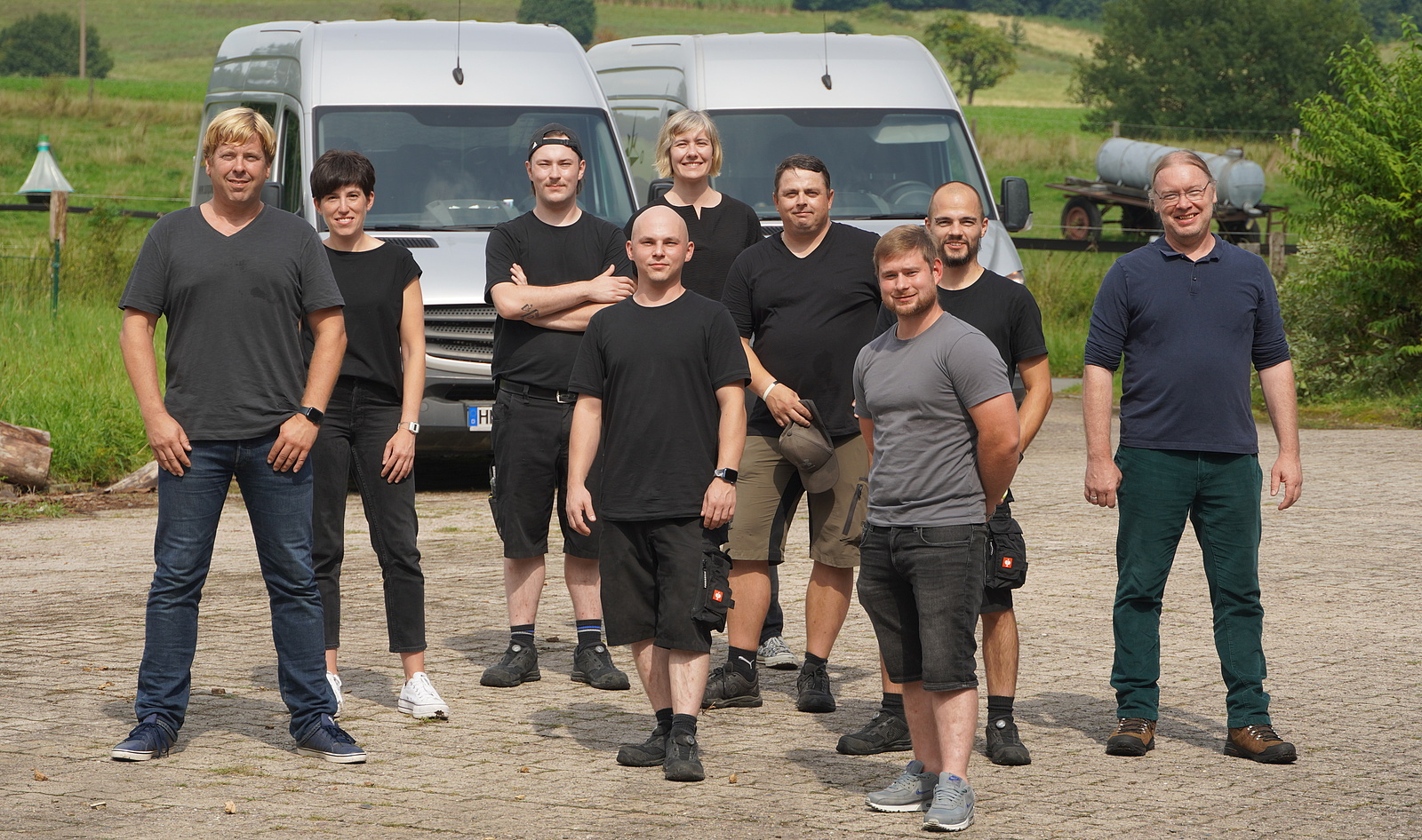 Das 9köpfige SUNPOWER Team steht draussen vor zwei Transportern