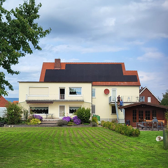 Gartenansicht von Einfamilienhaus mit Photovoltaikanlage