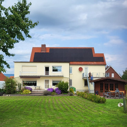 Gartenansicht von Einfamilienhaus mit Photovoltaikanlage