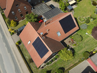 Drohnenaufnahme eines Einfamilienhauses mit Photovoltaik auf zwei Dachflächen