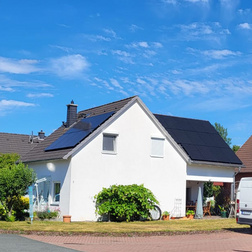 Straßenansicht eines Einfamilienhauses mit Photovoltaikanlage auf dem Dach