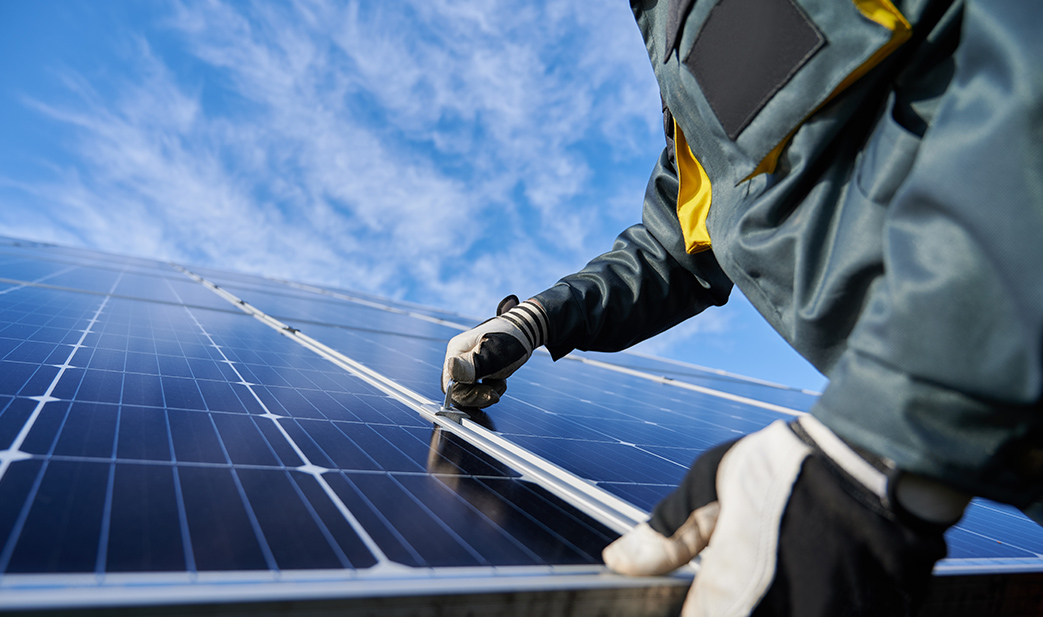 ein Monteur, der eine Fläche von Solarkollektoren montiert